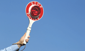 hand holding red sign with stop police text